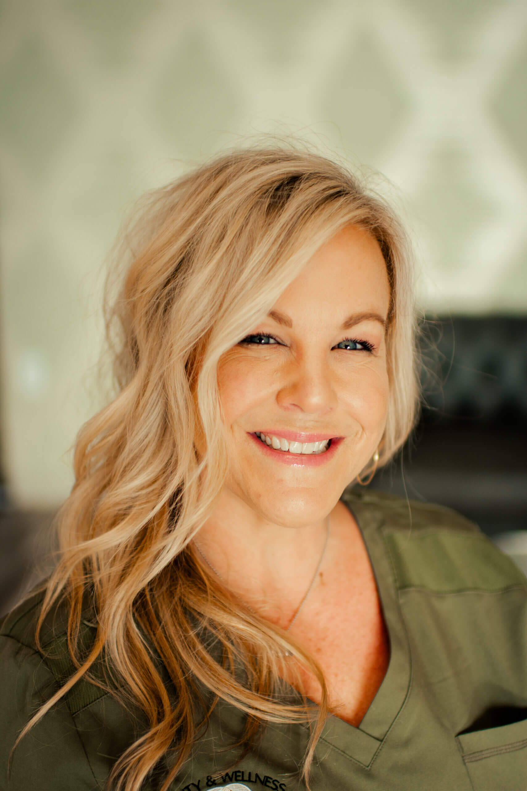A woman with long blonde hair smiling for the camera.