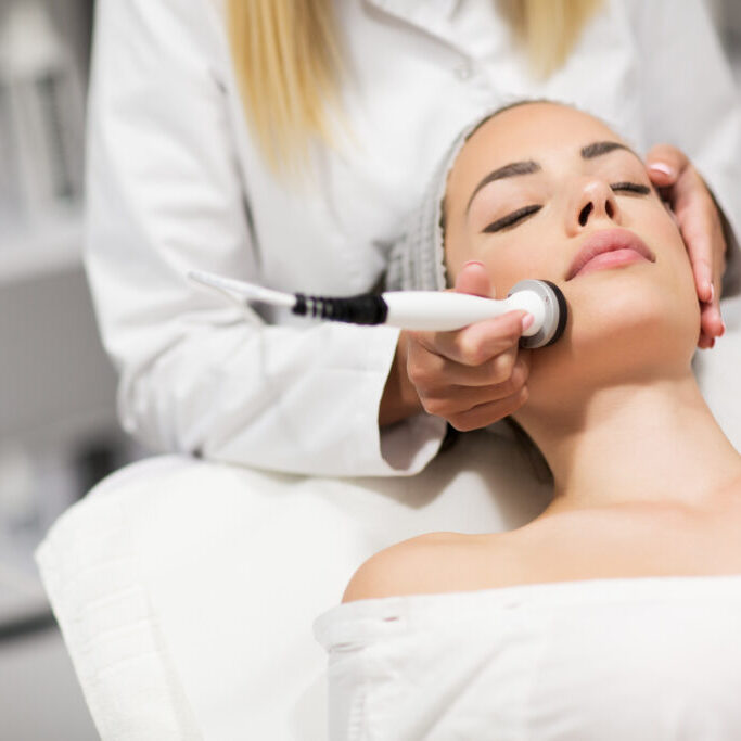 A woman getting her face cleaned by a professional