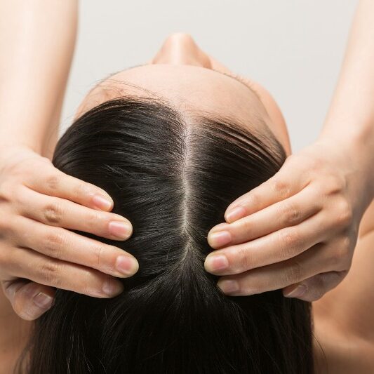 A woman with her hands on top of her head.